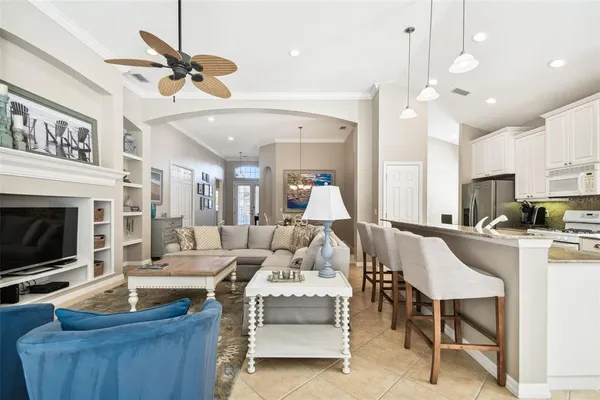 a living room with couches a dining table kitchen view and kitchen view