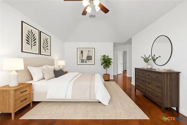 a spacious bedroom with a bed and a dresser