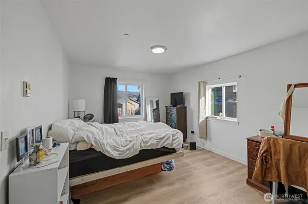 a bedroom with a bed and a flat tv screen on the dresser