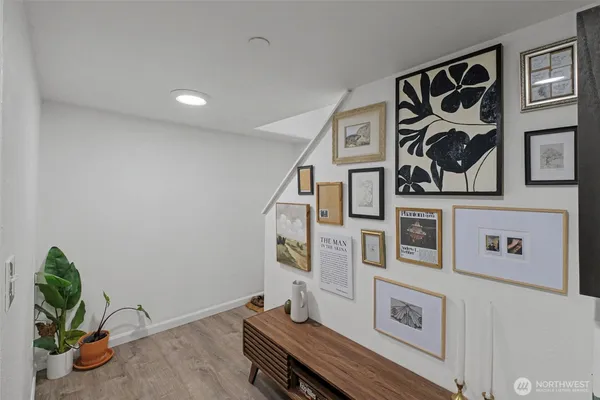 a room with painting on the wall and a potted plant