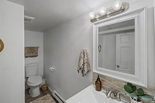 a bathroom with a toilet sink and mirror
