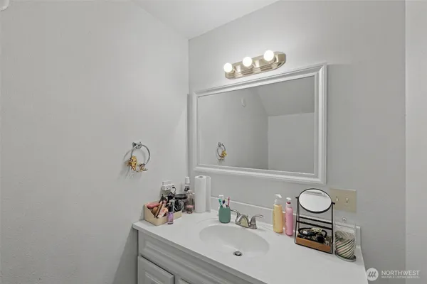 a bathroom with a sink a mirror and a lamp