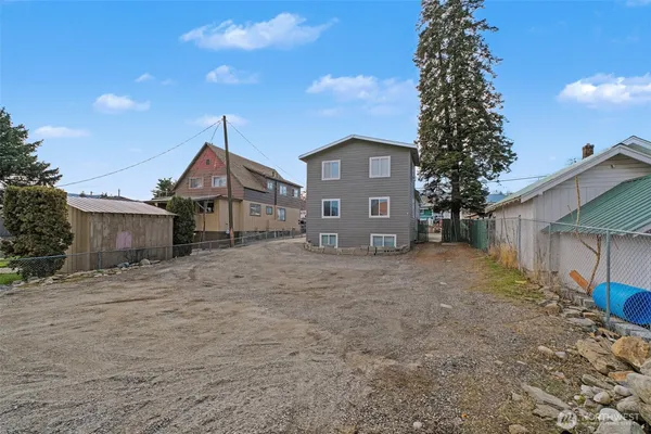 a view of a house with a yard and large tree