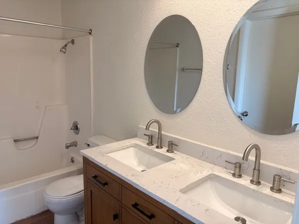 a bathroom with a granite countertop sink a toilet and a mirror