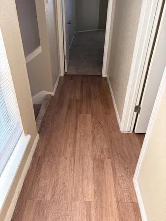 a view of a hallway in a house with wooden floor
