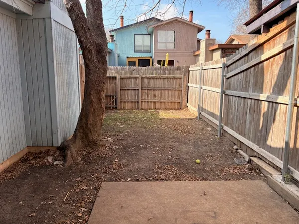 a view of a house with a small yard and wooden fence