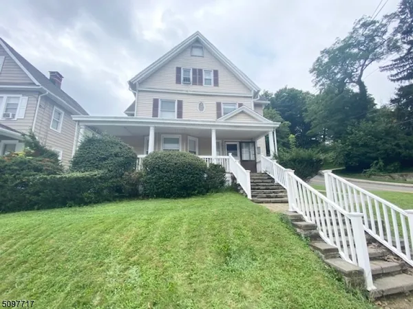 a front view of a house with yard and green space