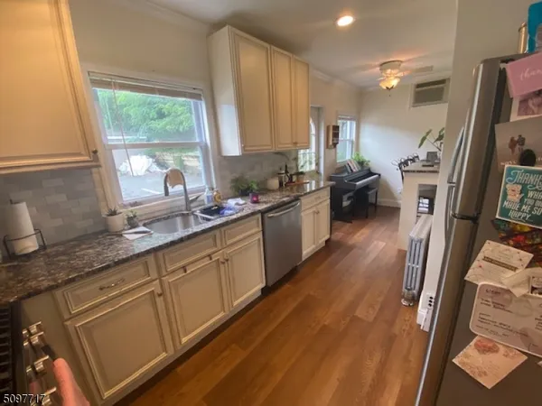 a large kitchen with stainless steel appliances a large window a sink and a counter top space