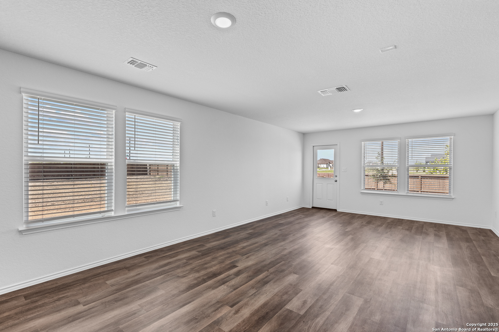416 Raven Row Marion, TX 78124 - Photo 10 of 29 a view of an empty room with wooden floor and a window
