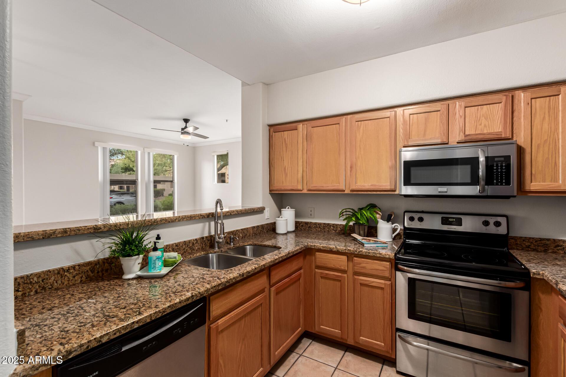 20100 North 78th Place, Unit 1064 Scottsdale, AZ 85255 - Photo 12 of 37 a kitchen with stainless steel appliances granite countertop a sink a stove a microwave and wooden cabinets