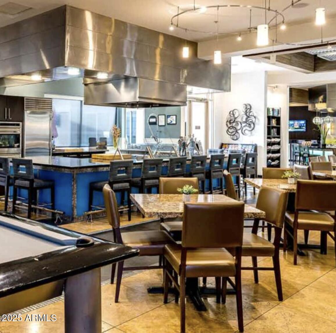 20100 North 78th Place, Unit 1064 Scottsdale, AZ 85255 - Photo 31 of 37 a dining room with stainless steel appliances kitchen island granite countertop a table chairs and a living room view