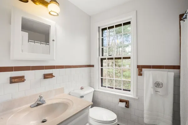 a bathroom with a sink vanity mirror and toilet