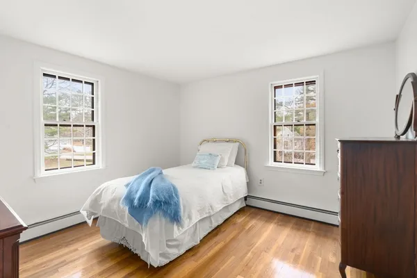 a bedroom with a bed and wooden floor