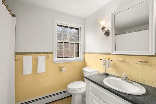 a bathroom with a granite countertop toilet a sink and a mirror