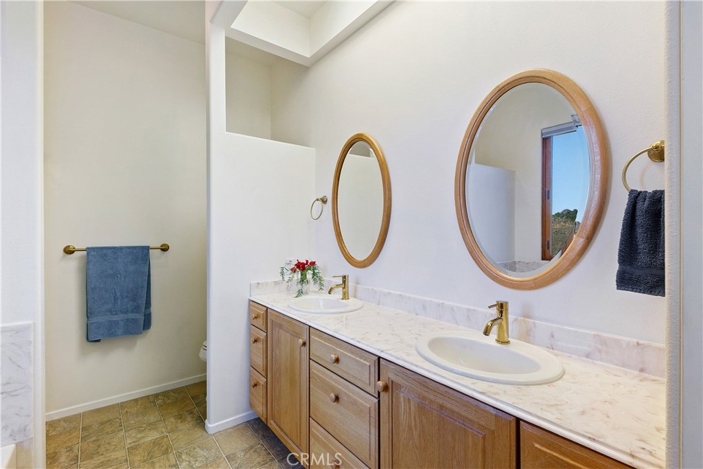 8400 Mipolomol Road Malibu, CA 90265 - Photo 32 of 59 a bathroom with a double vanity sink and a mirror