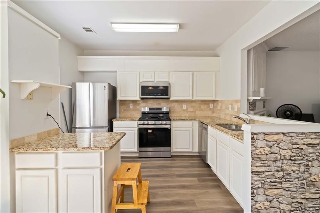 3752 Berkeley Crossing Duluth, GA 30096 - Photo 5 of 23 a kitchen with granite countertop a refrigerator stove and sink