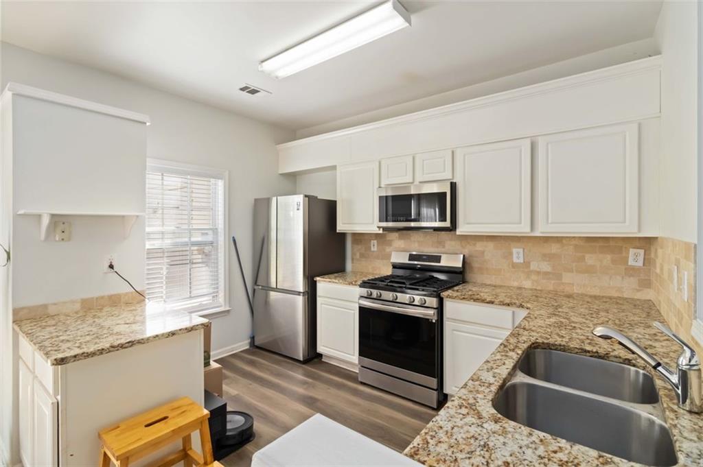 3752 Berkeley Crossing Duluth, GA 30096 - Photo 6 of 23 a kitchen with stainless steel appliances granite countertop a stove a sink and a refrigerator