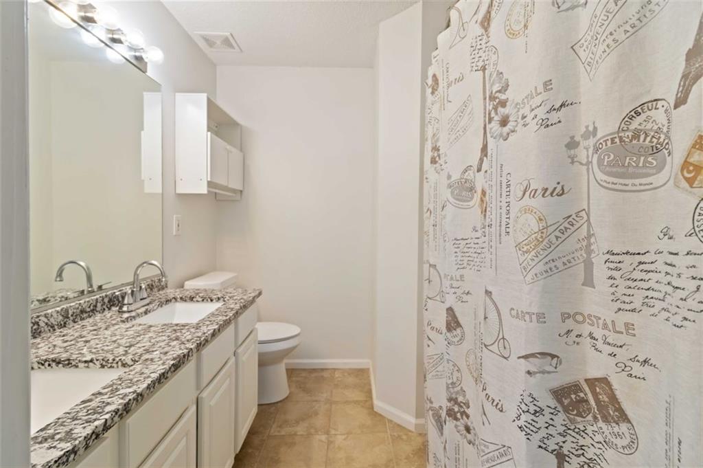 3752 Berkeley Crossing Duluth, GA 30096 - Photo 8 of 23 a bathroom with a granite countertop sink a toilet and shower curtain