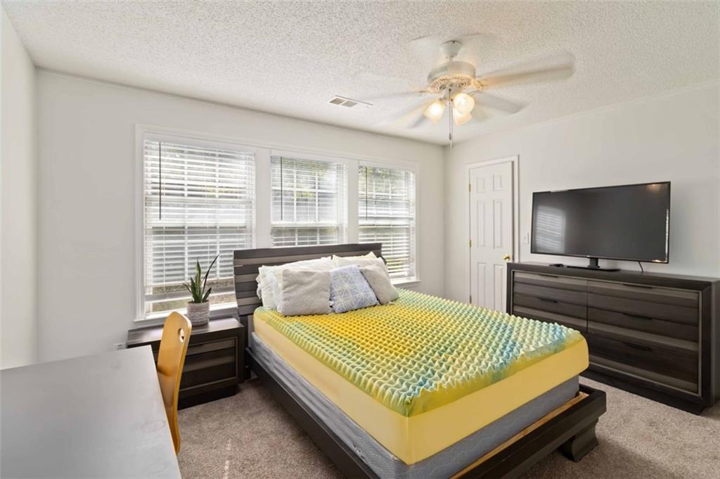 3752 Berkeley Crossing Duluth, GA 30096 - Photo 10 of 23 a bedroom with a bed and a flat screen tv
