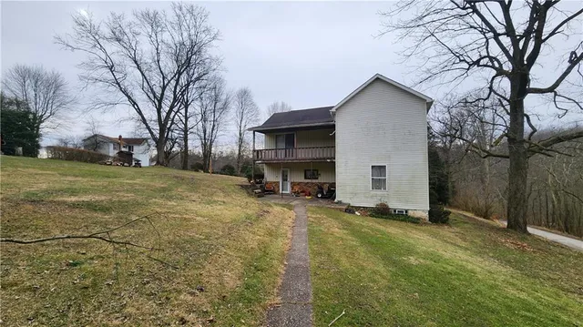 a view of a house with a yard covered in snow
