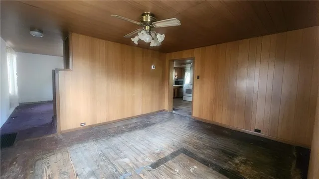an empty room with wooden floor closet and entryway