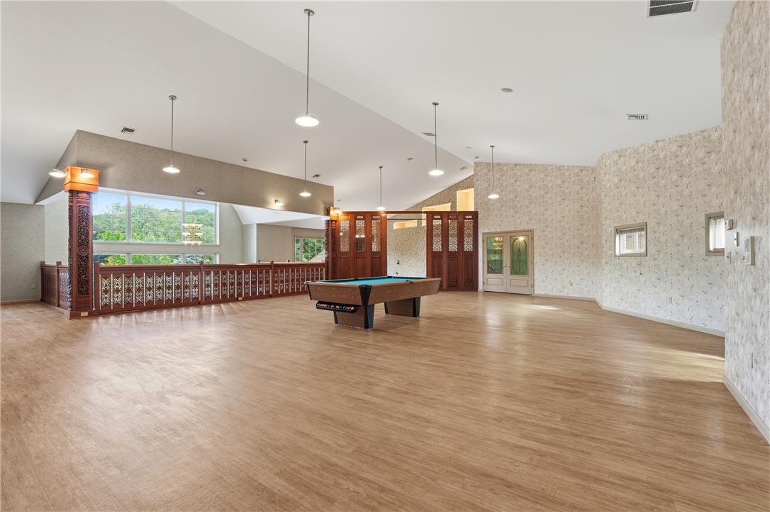 6271 Batman Road Zionsville, PA 18092 - Photo 72 of 100 An airy recreation room features abundant space for entertainment with large windows and hardwood flooring.
