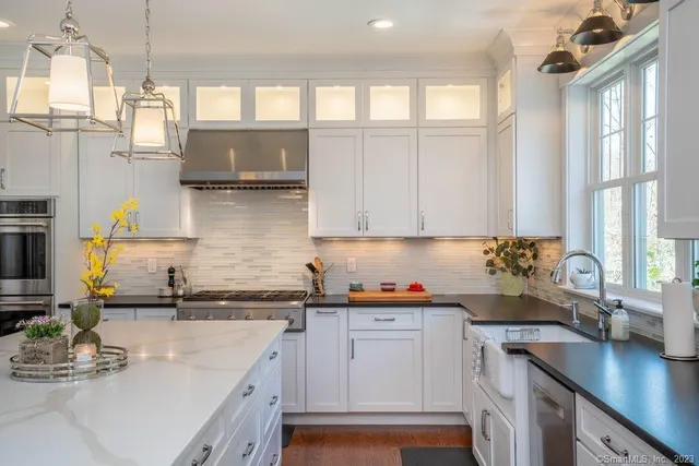 a kitchen with stainless steel appliances granite countertop a sink a stove and cabinets
