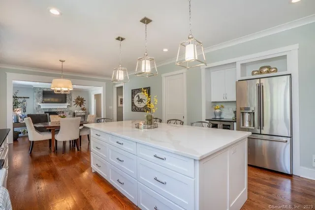 a large kitchen with kitchen island a large counter space a sink appliances and living room view