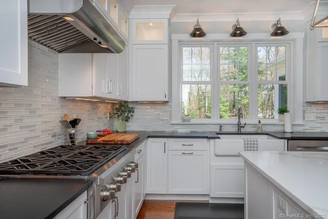 a kitchen with stainless steel appliances a sink a stove and a window
