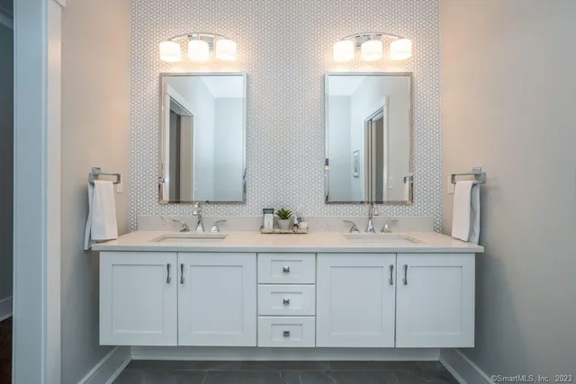 a bathroom with double sink and a mirror