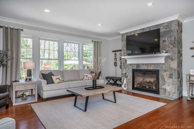 a living room with furniture a flat screen tv and a fireplace