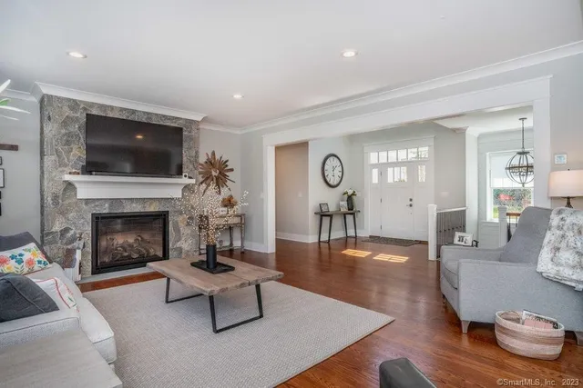 a living room with furniture a flat screen tv and a fireplace