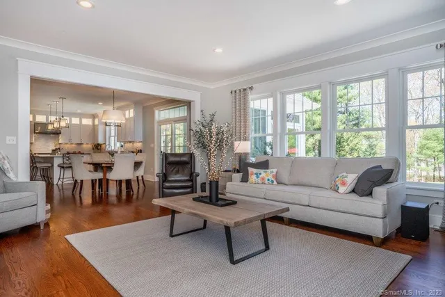 a living room with furniture wooden floor and a large window