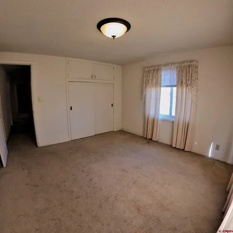 an empty room with windows and closet