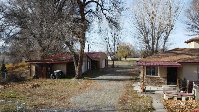 a front view of a house with garden and trees