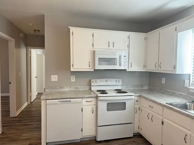 a kitchen with white cabinets and white appliances