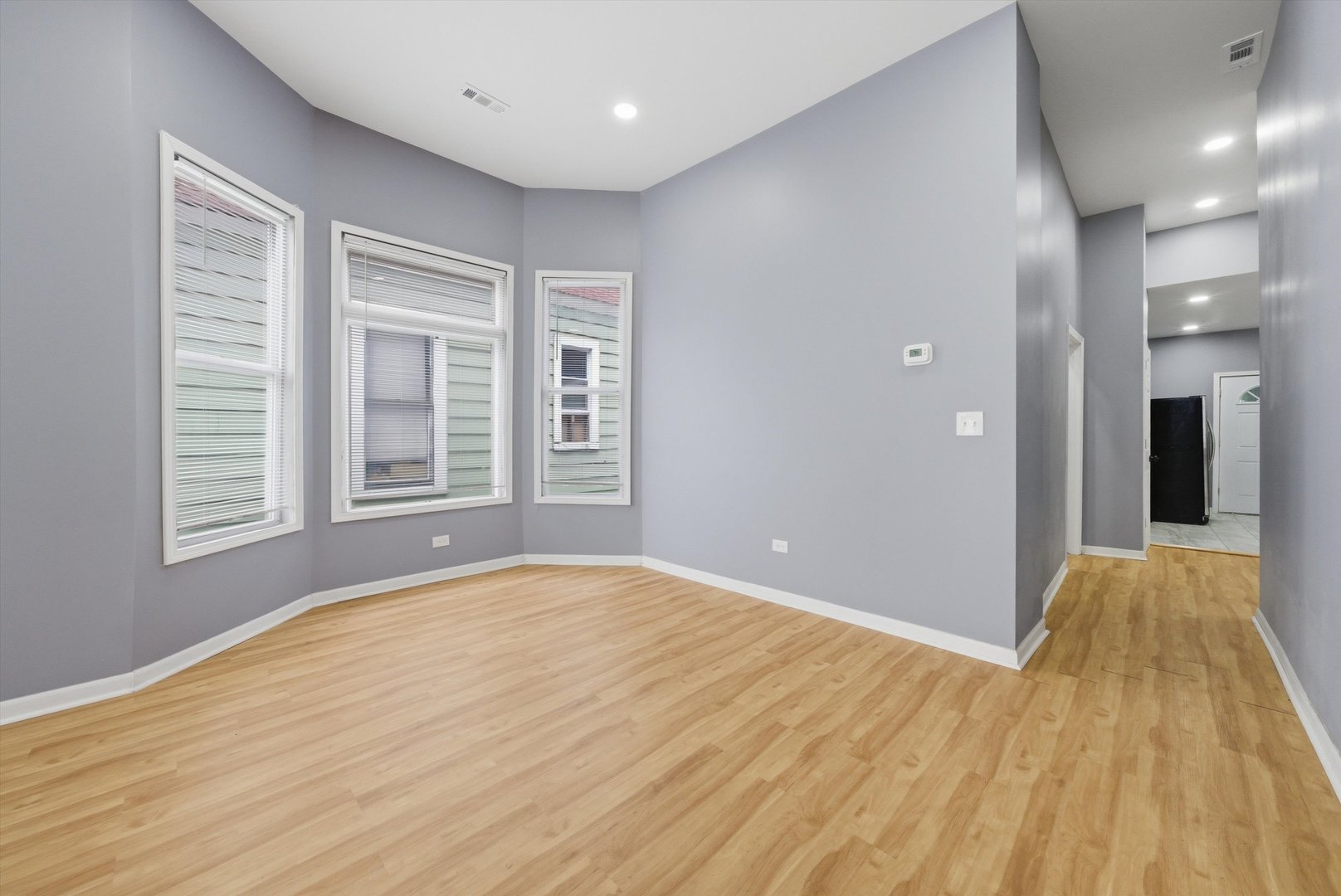 7828 South Escanaba Avenue Chicago, IL 60649 - Photo 11 of 41 a view of empty room with wooden floor and windows