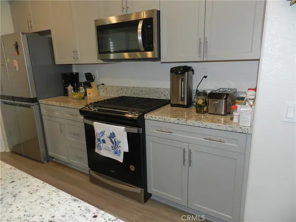a kitchen with stainless steel appliances granite countertop a refrigerator stove and sink