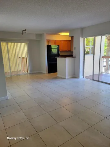 an empty room with windows and fireplace