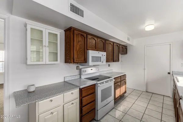 a kitchen with stainless steel appliances granite countertop a stove a sink and a microwave