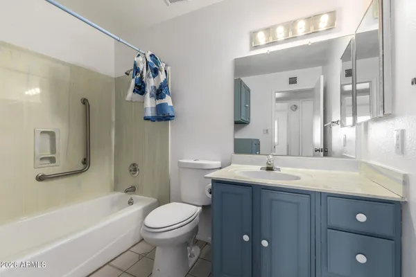 a bathroom with a sink vanity mirror bathtub and toilet