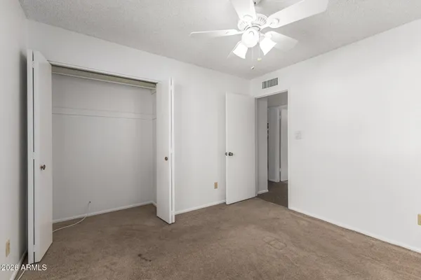 a view of an empty room with a ceiling fan