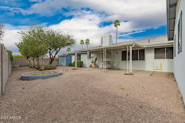 a backyard of a house with table and chairs