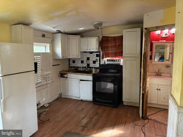 a kitchen with granite countertop a stove a sink and a refrigerator