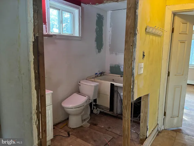 a white toilet sitting next to a bathroom sink and a mirror