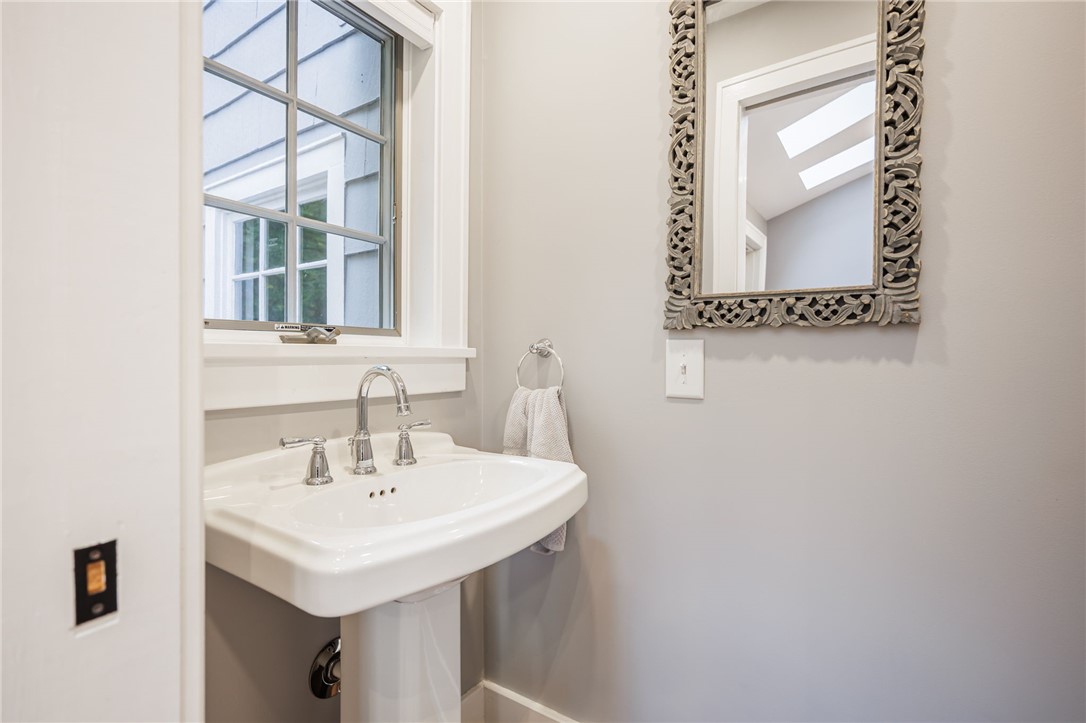 387 Kilbourn Road Rochester, NY 14618 - Photo 10 of 42 A classic pedestal sink sits beneath a bright window in this charming powder room.