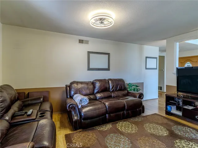 a living room with furniture a flat screen tv and a window