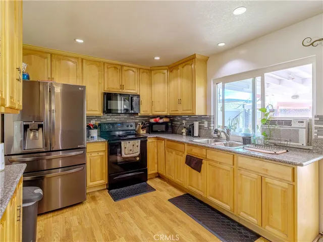 a kitchen with stainless steel appliances a refrigerator sink and microwave