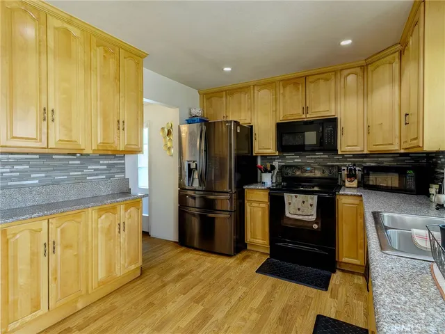 a kitchen with a refrigerator and a stove top oven