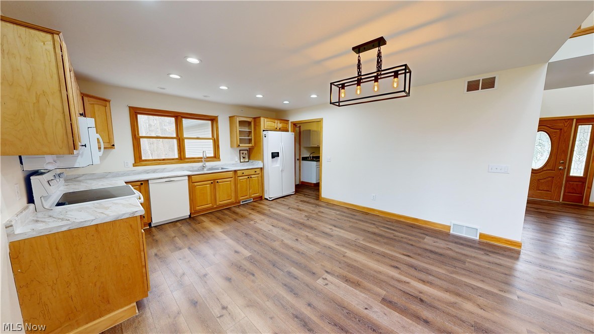 15548 Trask Road Thompson, OH 44086 - Photo 10 of 31 Kitchen featuring hanging light fixtures, light hardwood / wood-style floors, white appliances, and sink
